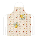 Lemon and pine Christmas apron laid flat with white neck and waist straps, showing watercolour lemons on leafy branches among small rust and gold Christmas trees, stars and crescent moons on cream