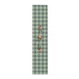 Pomegranate & Pine Gingham Christmas table runner, a pomegranate, pine cone, orange slice and gold star under a pine spray on a sage green gingham check