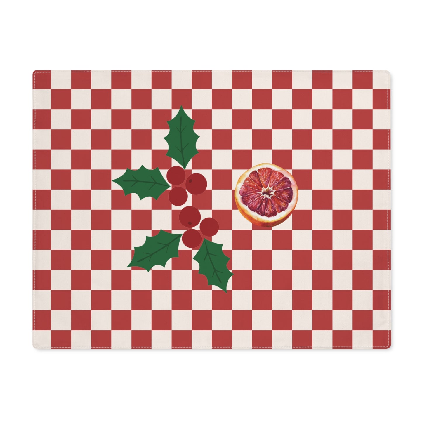 Blood orange check Christmas placemat laid flat, a red and cream checkerboard with holly and a cut blood orange