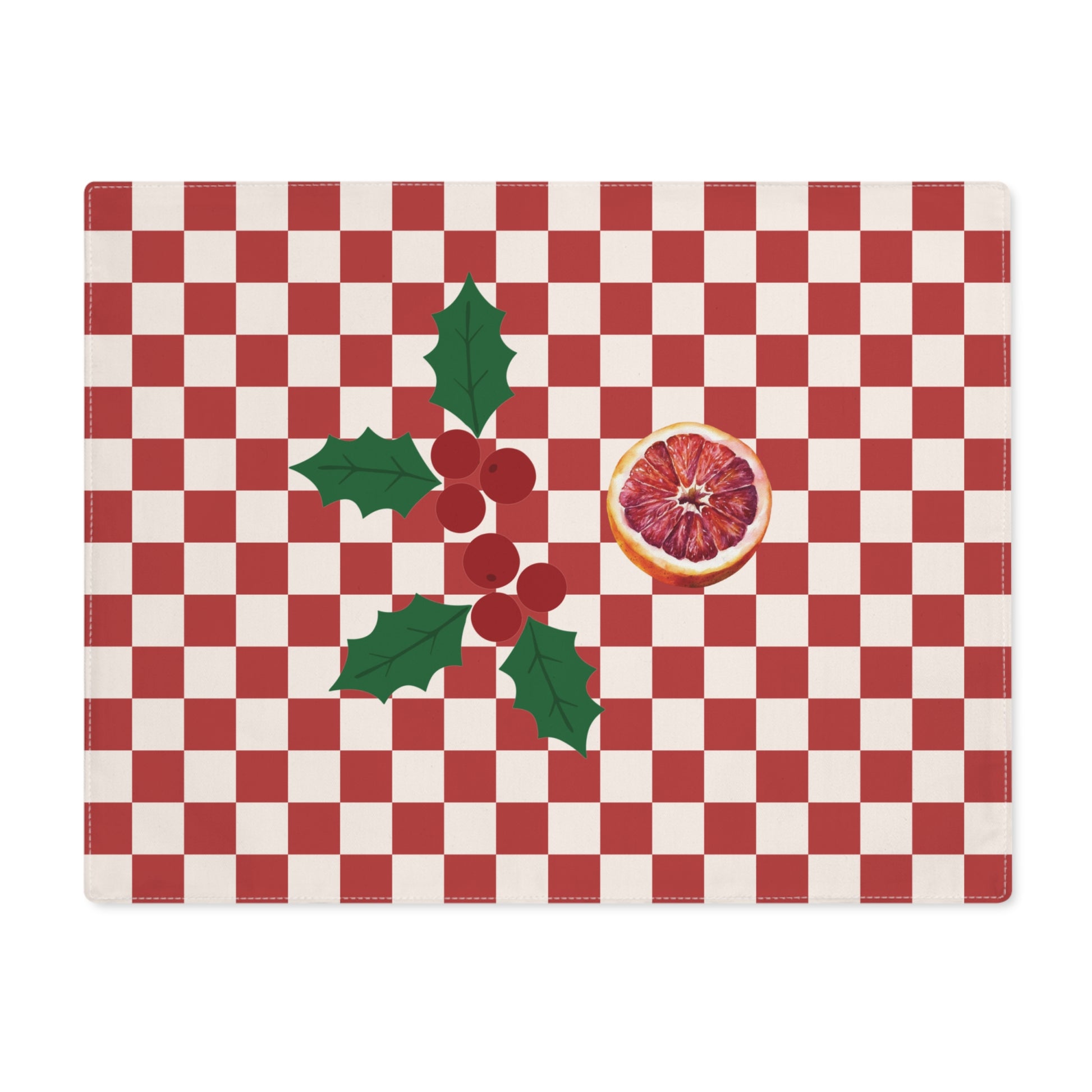 Blood orange check Christmas placemat laid flat, a red and cream checkerboard with holly and a cut blood orange