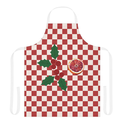 Blood orange check Christmas apron laid flat with white neck and waist straps, a red and cream checkerboard with holly and a cut blood orange