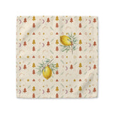 Lemon and pine Christmas cloth napkin laid flat, with watercolour lemons among small rust and gold Christmas trees, stars and crescent moons on cream