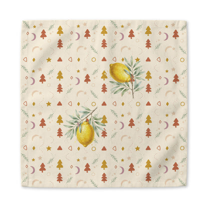 Lemon and pine Christmas napkin laid flat, the print running out to the hemmed edge on the cream ground