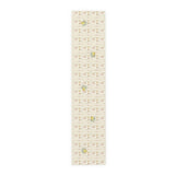 Lemon and pine Christmas table runner laid flat, with watercolour lemons among small rust and gold Christmas trees, stars and crescent moons on cream