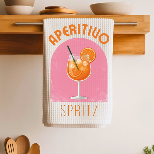 Aperitivo Spritz tea towel folded over a wooden shelf rail above a kitchen counter