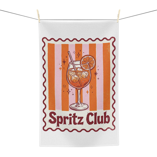 Spritz Club tea towel hanging, showing the orange striped panel with a spritz glass and Spritz Club lettering