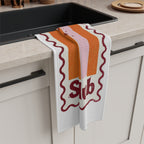 Spritz Club tea towel draped over the edge of a kitchen cabinet