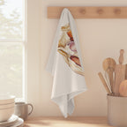 Garlic tea towel hanging from a peg rail beside a window, with wooden utensils and stacked bowls