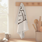 Caffè Italiano tea towel hanging from a peg rail beside a window, with wooden utensils and stacked bowls
