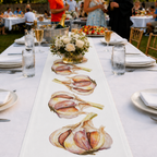 Garlic table runner down a long white banquet table set with flowers and glasses