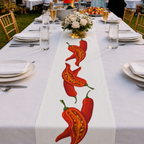 Chili Pepper table runner down a long white banquet table set with flowers and glasses