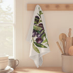 Olive Branch tea towel hanging from a peg rail beside a window, with wooden utensils and stacked bowls