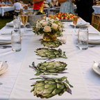 Artichoke table runner down a long white banquet table set with flowers