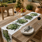 Artichoke table runner on an outdoor wooden table set with plates and greenery