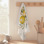 Amalfi Summer tea towel hanging from a peg rail beside a window, with wooden utensils and stacked bowls
