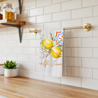 Amalfi Summer tea towel hanging from a brass rail against white subway tile