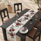 Pomegranate table runner on a dark wooden table with chairs and wine glasses