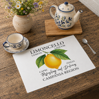 Limoncello placemat on a wooden table with a blue-patterned cup and teapot and a jug of daisies