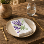 Lavender napkin on a cream plate with a glass of water and a terracotta vase of Mediterranean wildflowers