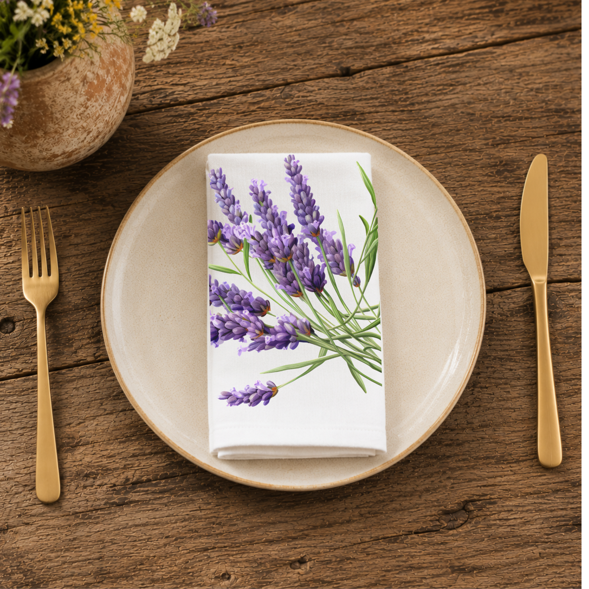 Lavender napkin folded on a cream plate between gold cutlery, beside a terracotta vase of Mediterranean wildflowers