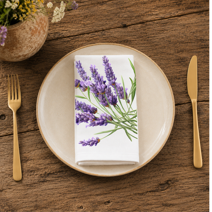 Lavender napkin folded on a cream plate between gold cutlery, beside a terracotta vase of Mediterranean wildflowers