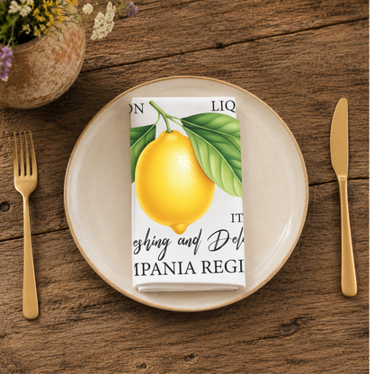 Limoncello napkin folded on a cream plate between gold cutlery, beside a terracotta vase of Mediterranean wildflowers