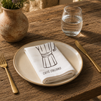 Caffè Italiano napkin on a cream plate with a glass of water and a terracotta vase of Mediterranean wildflowers