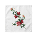 Pomegranate cloth napkin laid flat, a watercolor branch with fruit and orange blossom running corner to corner