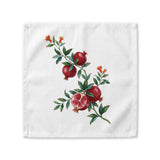 Pomegranate cloth napkin laid flat, a watercolor branch with fruit and orange blossom running corner to corner
