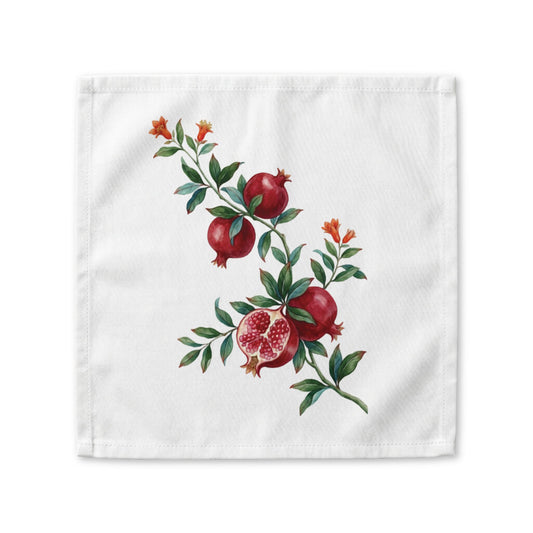 Pomegranate cloth napkin laid flat, a watercolor branch with fruit and orange blossom running corner to corner