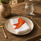 Chili Pepper napkin on a cream plate with a glass of water and a terracotta vase of wildflowers
