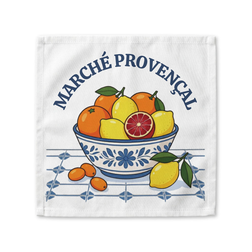Marché Provençal cloth napkin laid flat, showing a blue and white bowl of oranges and lemons on white cotton