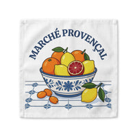 Marché Provençal cloth napkin laid flat, showing a blue and white bowl of oranges and lemons on white cotton