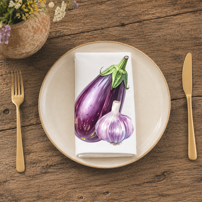 Eggplant and Garlic napkin folded on a cream plate between gold cutlery, beside a terracotta vase of Mediterranean wildflowers