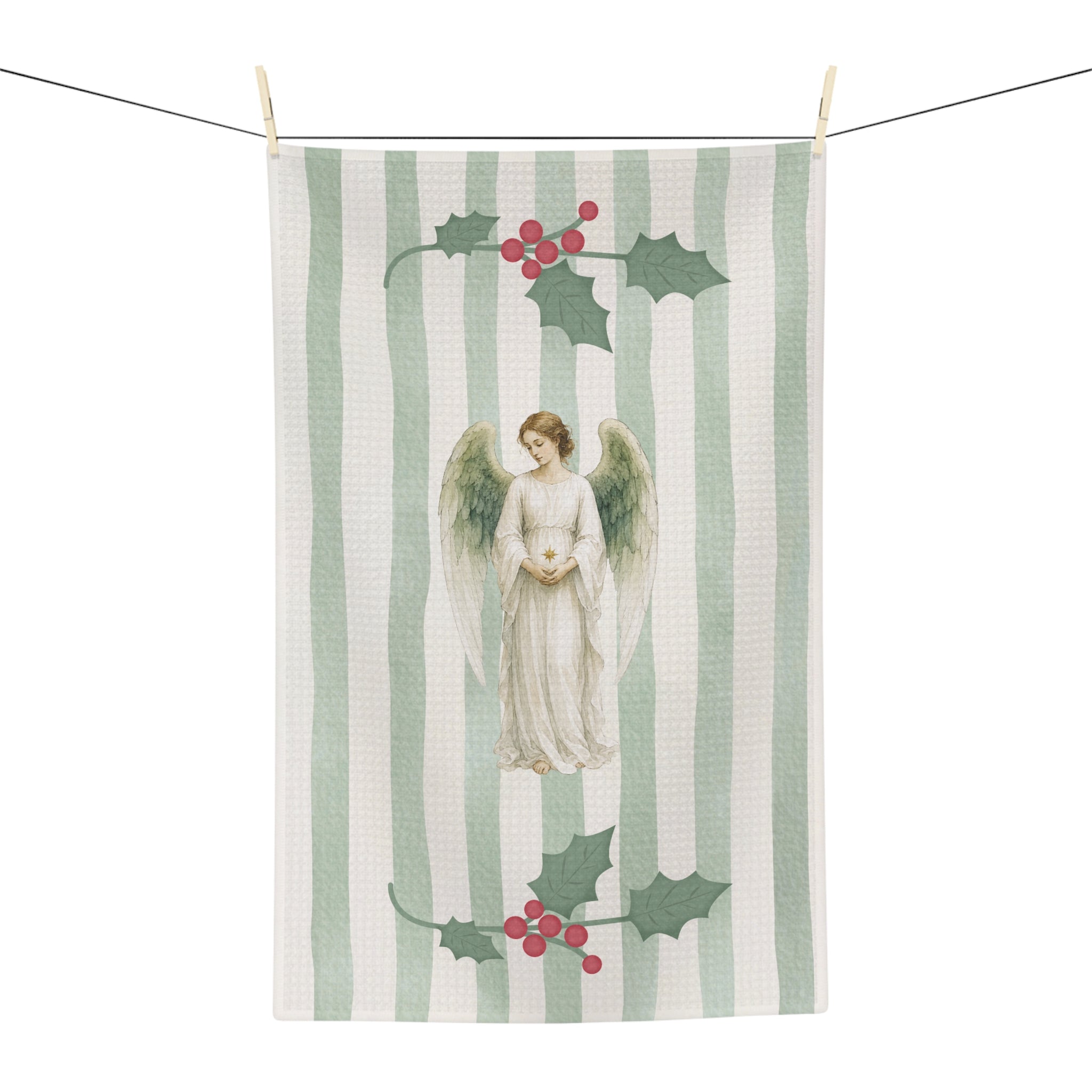 Angels and holly Christmas tea towel on a washing line, shown flat with the angel and red-berried holly on a soft green stripe