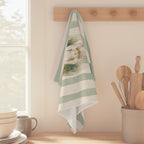Angels and holly Christmas tea towel draped over a kitchen counter beside a black sink