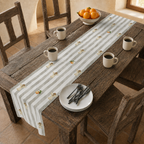Angels and oranges Christmas table runner down a rustic wooden table, with a bowl of oranges, coffee mugs and stacked plates