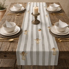 Angels and oranges Christmas table runner on a table set with cream bowls, gold cutlery and a lit candle