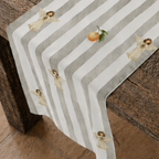 Angels and oranges Christmas table runner on a set table, showing the cream angels and oranges on the grey and cream stripe
