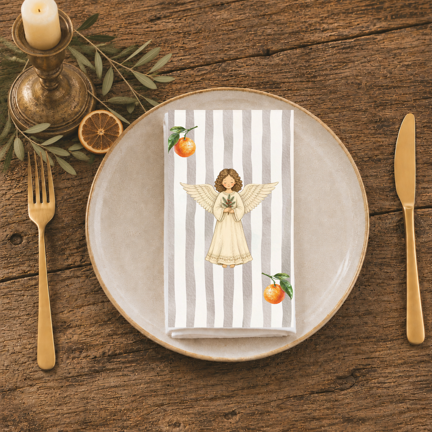 Angels and oranges napkin folded on a stoneware plate, seen from above with gold cutlery and a sprig of greenery