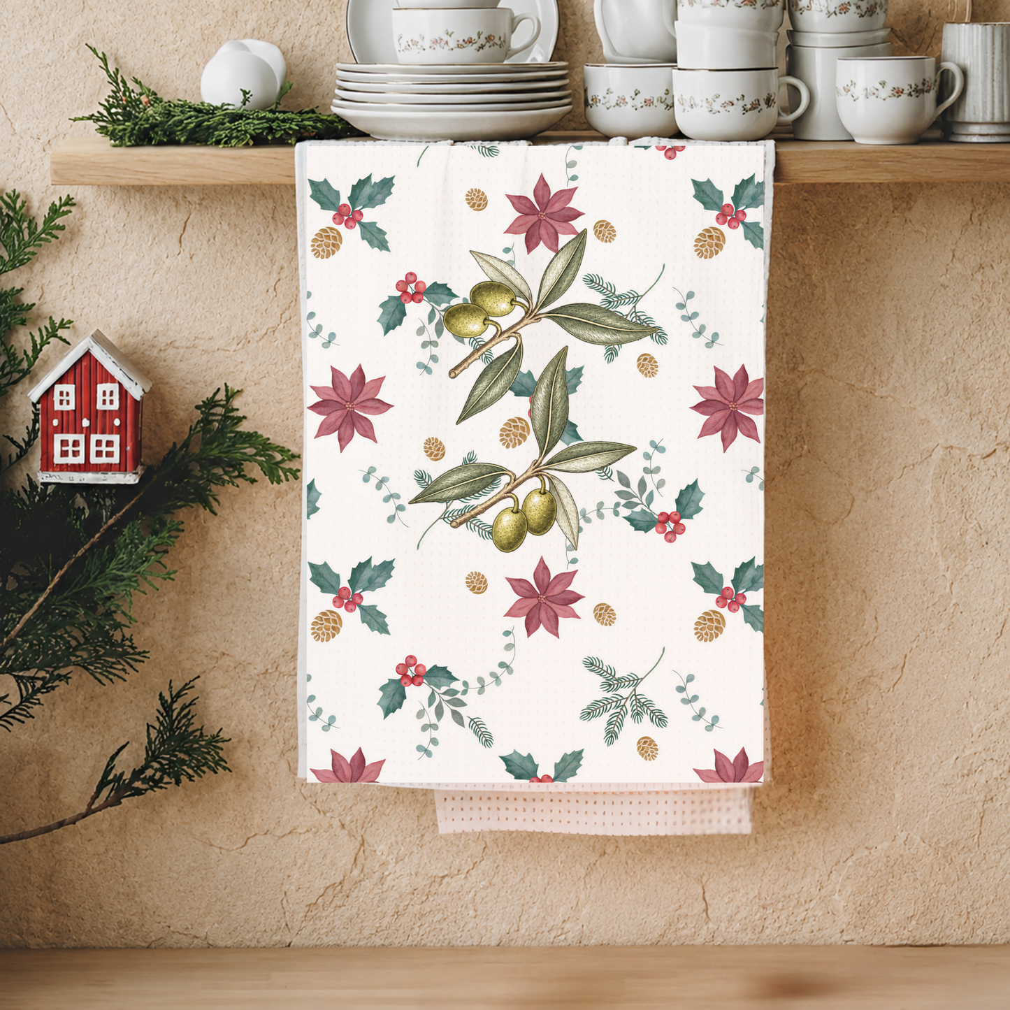 Christmas kitchen towel over a wooden shelf below stacked cups and saucers