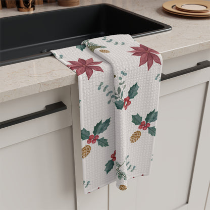 Poinsettia and olive kitchen towel folded over a counter edge beside a dark sink