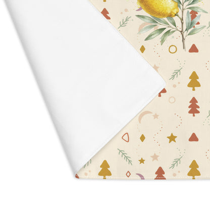 Corner of the lemon and pine Christmas placemat folded back, showing the stitched hem and the plain reverse