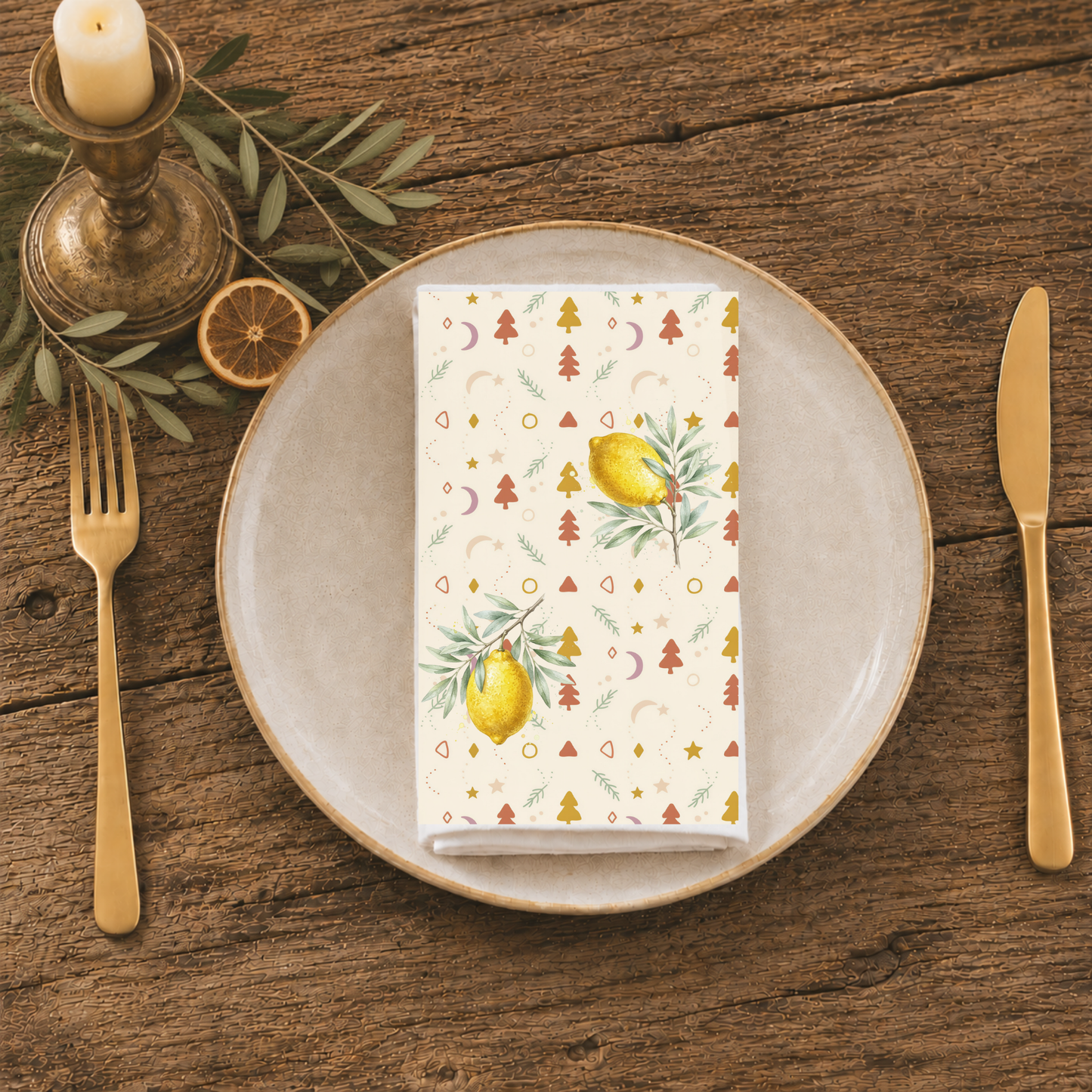 Lemon and pine Christmas napkin folded on a plate at a table laid for Christmas