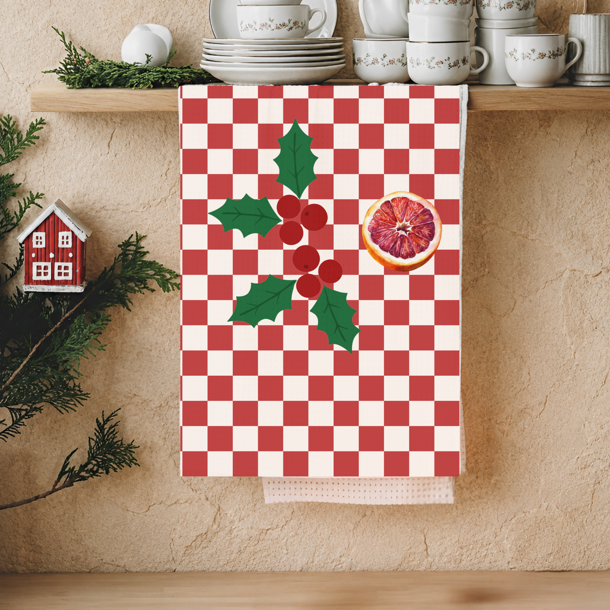 Blood orange check Christmas kitchen towel hanging in a kitchen, the check and cut orange in view