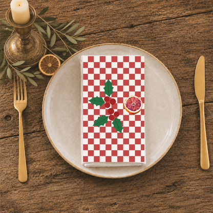 Blood orange check Christmas napkin folded on a plate at a table laid for Christmas