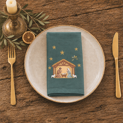 Nativity & Olive Christmas cloth napkin folded at a place setting, the nativity stable on deep green