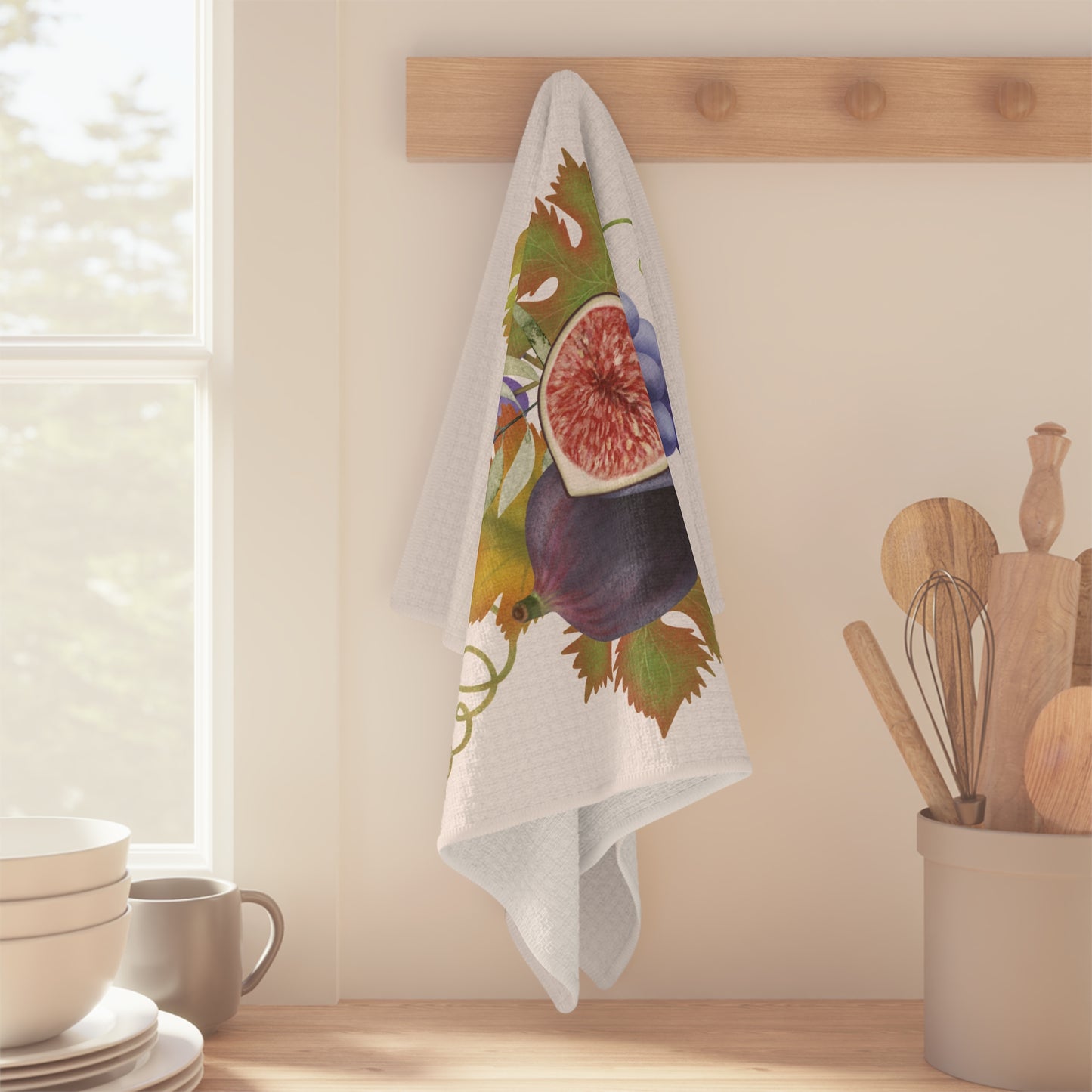 Fig & Grape fall tea towel, purple grapes and turning vine leaves, folded on a counter