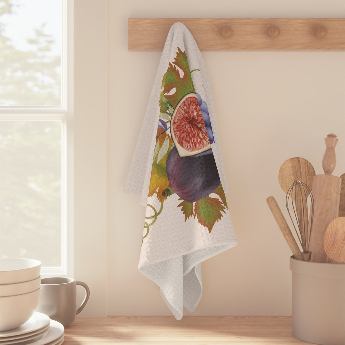 Fig & Grape fall tea towel, purple grapes and turning vine leaves, folded on a counter