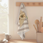Angels and oranges Christmas tea towel hanging from a wooden peg rail beside a sunlit kitchen window